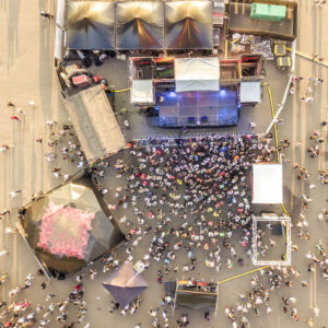 aerial top view of crowd of people standing near the stage on a concert on summer day